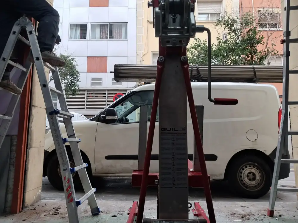 Equipo de Accesos Nordeste instalando una persiana metálica con elevador en Barcelona