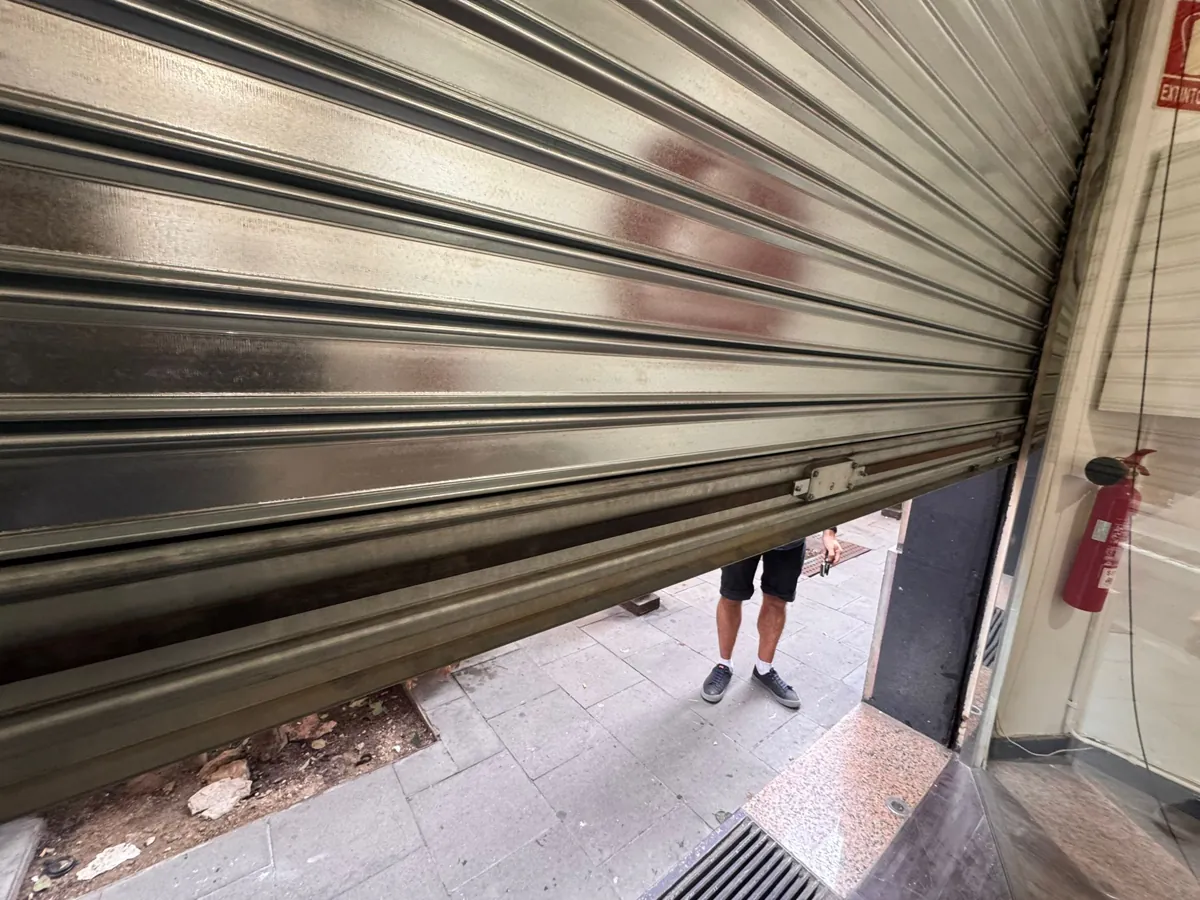 Persiana metálica galvanizada recién montada, vista desde el interior del local