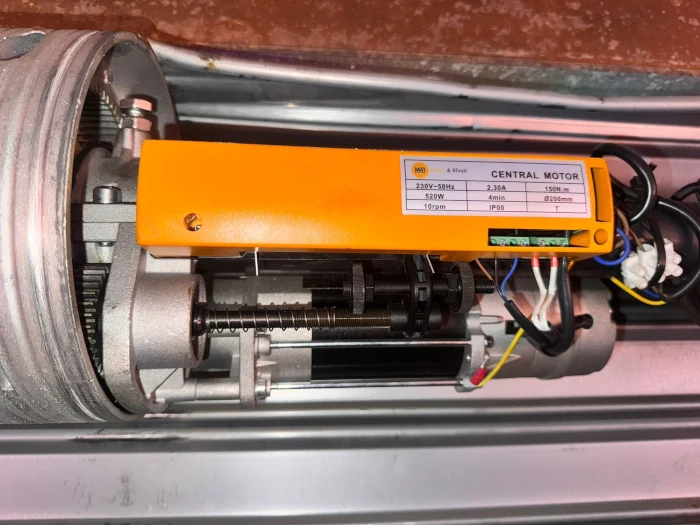 Motor instalado en el eje de una persiana metálica en Barcelona