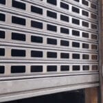 Puerta metálica enrollable parcialmente abierta