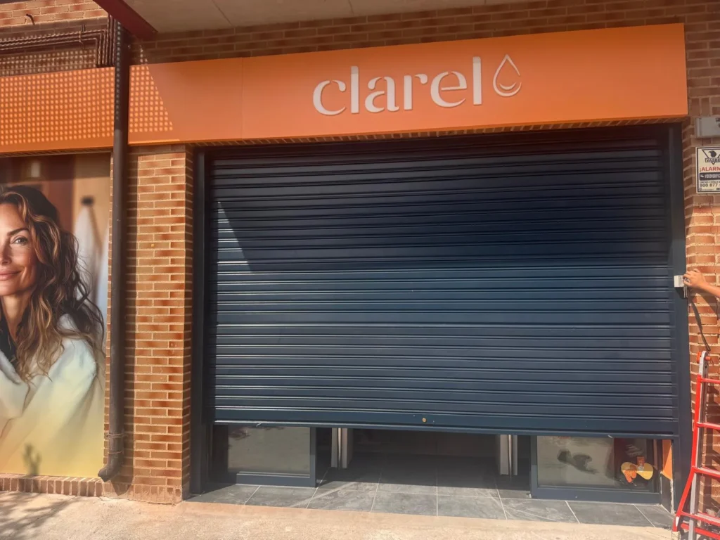 Persiana de seguridad enrollable en fachada de tienda.