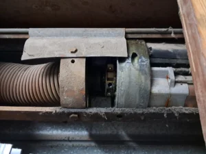 Mecanismo interno de motor y eje de persiana enrollable después de una reparación técnica.
