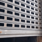 GIF de persiana metálica enrollable mostrando apertura y cierre en bucle, con enfoque en el movimiento y el mecanismo.