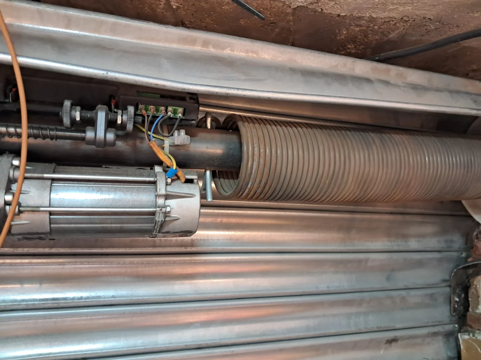 Mecanismo interno de persiana metálica, en mantenimiento.