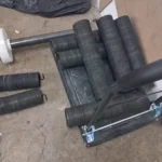 Muelles de torsión metálicos enrollados con ganchos sobre una plataforma en taller.