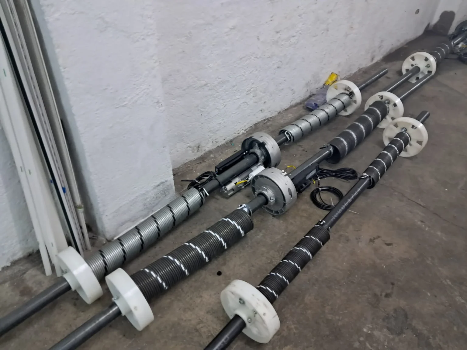 Muelles de torsión montados en ejes con tambores y placas de apoyo.