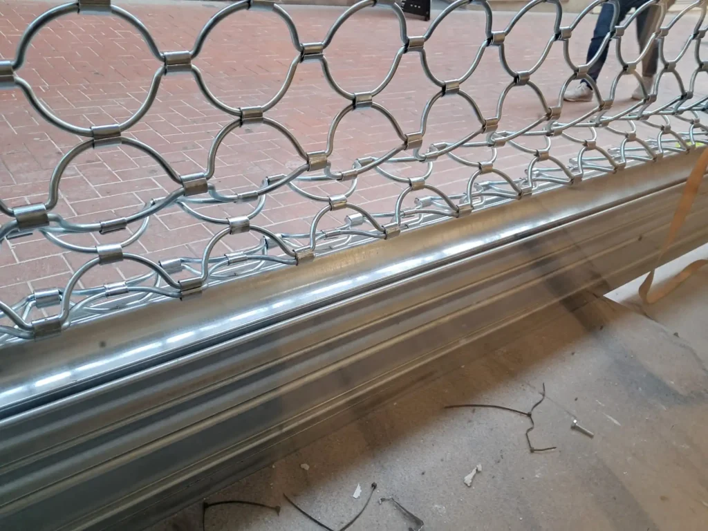 Reja de seguridad metálica de ballesta con diseño de semicírculos en proceso de instalación por Accesos Nordeste en Barcelona.