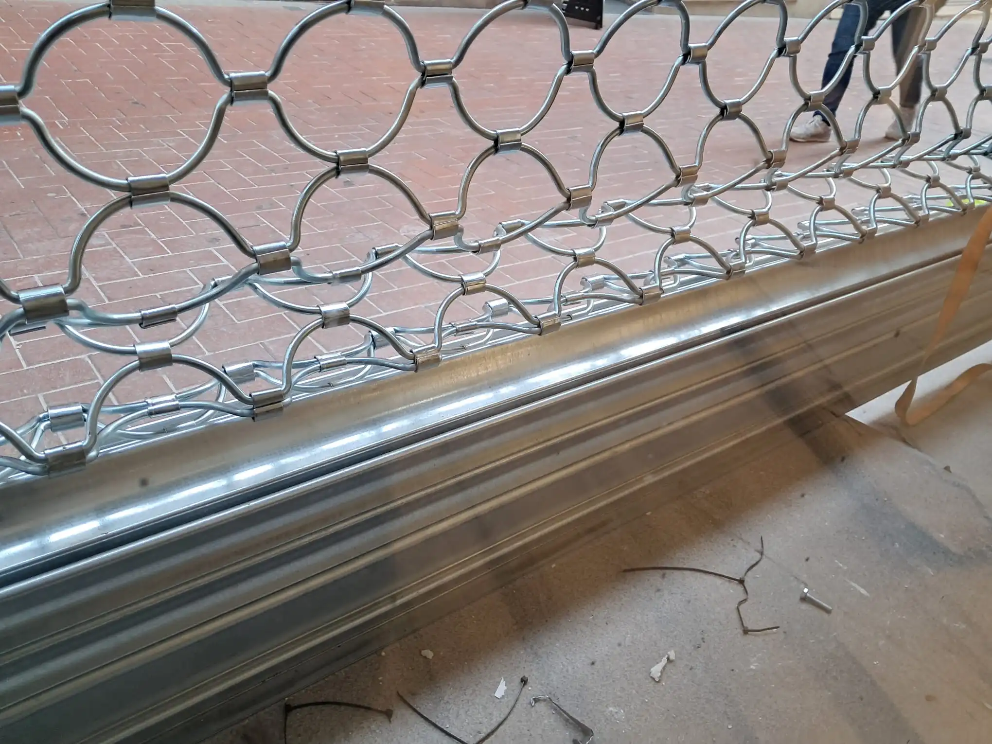 Reja de seguridad metálica de ballesta con diseño de semicírculos en proceso de instalación por Accesos Nordeste en Barcelona.