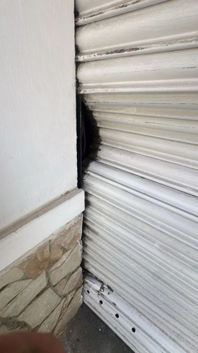 Imagen de una persiana metal atascada debido al descarrilamiento de las lamas de seguridad.