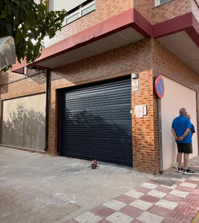 Entrada con puerta enrollable de piedra y acceso estrecho.
