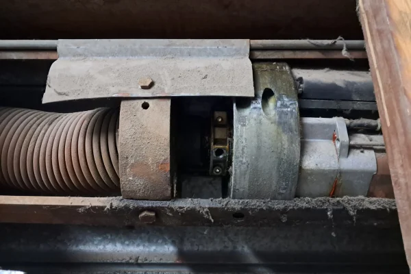 Mecanismo interno de motor y eje de persiana enrollable después de una reparación técnica.