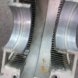 Disipador de aluminio con dos canales semicilíndricos y lubricante visible.