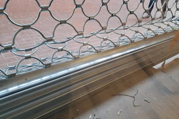 Reja de seguridad metálica de ballesta con diseño de semicírculos en proceso de instalación por Accesos Nordeste en Barcelona.