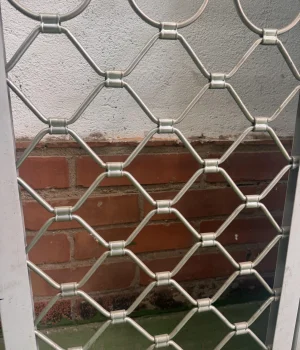 Reja metálica de seguridad con diseño hexagonal tipo panal para locales comerciales.